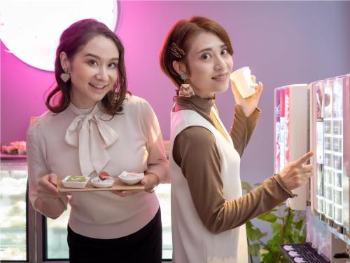 two women holding a plate of food and a drink at デザイナーズホテル アリス -Adult only- in Sasebo