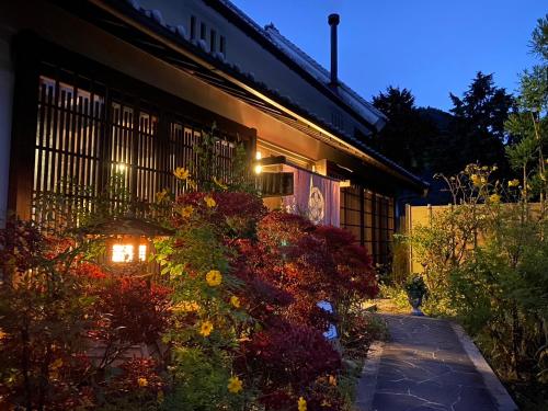 a building with a bunch of flowers in front of it at Minshuku Murou in Uda