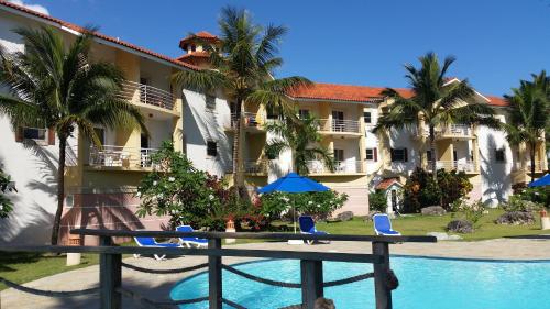 uma vista para um resort com uma piscina e palmeiras em Garden Studio At Ocean Dream Resort em Cabarete