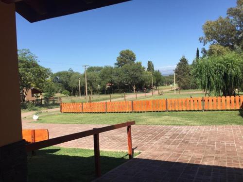 a park with an orange fence and a bench at Cabañas MAHALO in Villa Rumipal