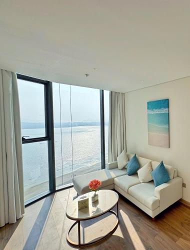 a living room with a white couch and a table at A la carte Residence - high floor in Ha Long
