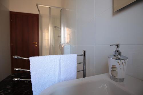 a white bathroom with a sink and a towel at B&B Tarì in Siracusa