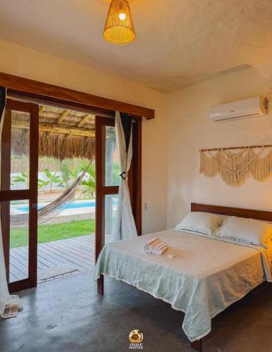a bedroom with a bed and a sliding glass door at Moitas Chalés in Amontada