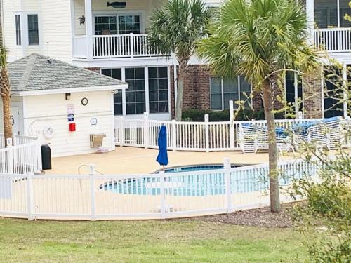 a white fence around a swimming pool in a house at Calming & Relaxing condo in the center of MB in Myrtle Beach