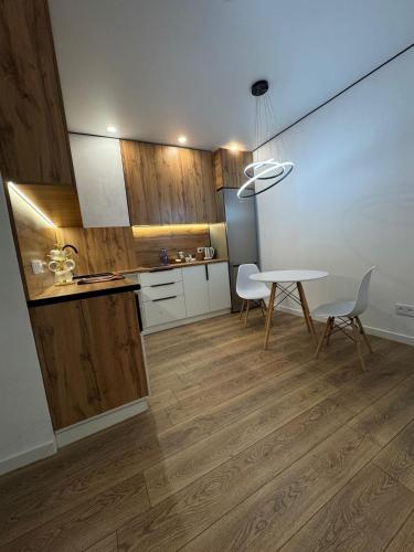 a kitchen with a table and chairs in a room at Стильная однокомнатная квартира in Almaty