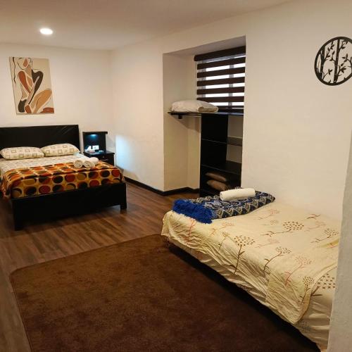 a bedroom with two beds and a tv in it at Suite La Pergola - El Renacimiento Suites in Cuenca