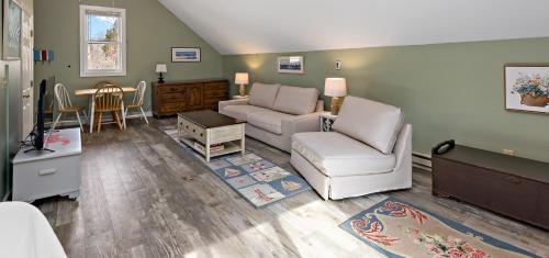 a living room with a couch and chairs and a table at Inn at the Oaks in Eastham