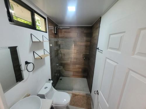 a small bathroom with a toilet and a shower at Villa Rios in Talamanca
