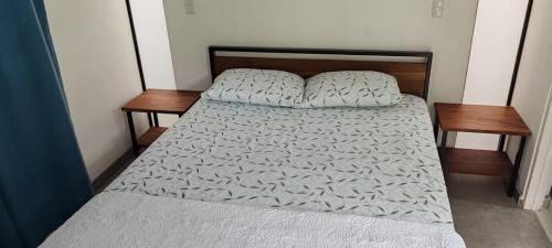 a bed in a room with two wooden tables at Villa Rios in Talamanca