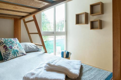 a bedroom with a bed with a ladder and a window at Departamento amplio con alberca y asador - Hasta 14 personas - B3 in Puerto Vallarta