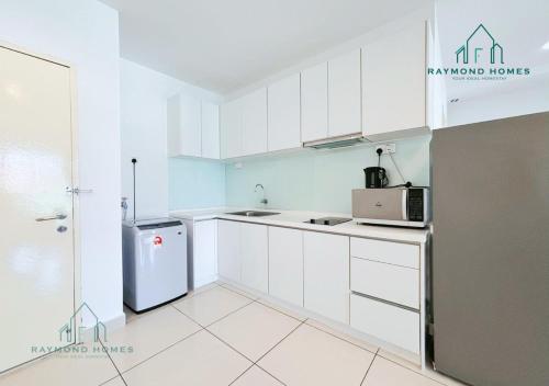 a kitchen with white cabinets and a refrigerator at Gurney Drive Mansion One Serviced Apartment in George Town