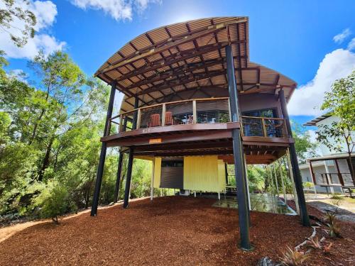 a tree house with a deck on top at EUROLIE ON HIGH at Kingfisher Bay Fraser Island in Kingfisher Bay