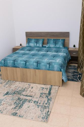 a bed with a blue comforter and blue pillows at Dar El Yasamine in Houmt Souk