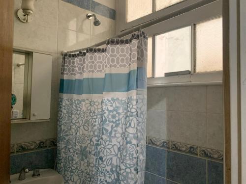 a bathroom with a shower curtain and a window at corazón obelisco 2 in Buenos Aires