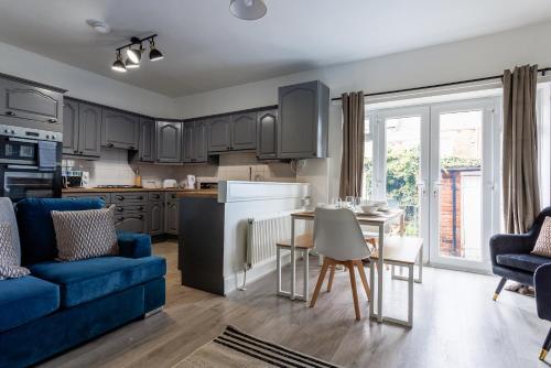 a kitchen and living room with a blue couch and a table at Gateshead 4 BR Home for Serenity Stay in Gateshead