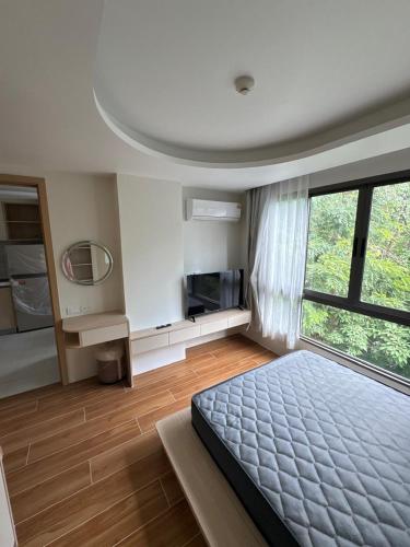 Un dormitorio con una cama y una ventana grande. en 1 bedroom in Kamala Beach, en Kamala Beach