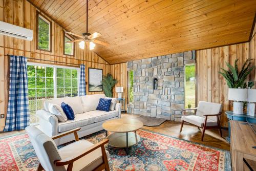 a living room with a couch and a stone wall at Modern Cabin w Mountain View Hot Tub & Fire Pit in Morton Grove