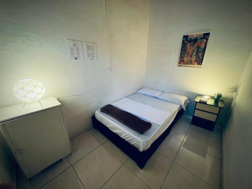 a small bedroom with a bed and two night stands at Hostal Mamaquilla in Pasto
