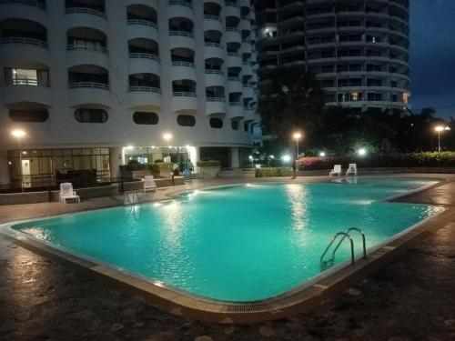 a large swimming pool in front of a building at night at Vip Condo Rayong beach in Rayong