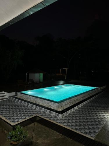 a swimming pool lit up at night at Sriwaree Pool Villa Khao Lak - 8 meters pool - 3 bedroom - 2 bath in Khao Lak