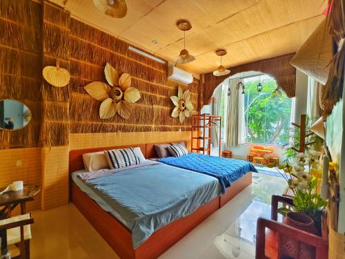 a bedroom with a bed with a flower on the wall at Sea Urchin Homestay in Phan Rang