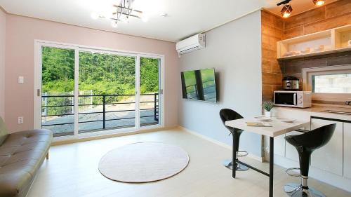 a kitchen and a living room with a table and chairs at Hongcheon stone brown Pension in Hongcheon
