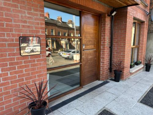 a door to a building with a reflection of a car in the window at 4 star Rating 2 bed Newly renovated city apartment with free parking in Belfast