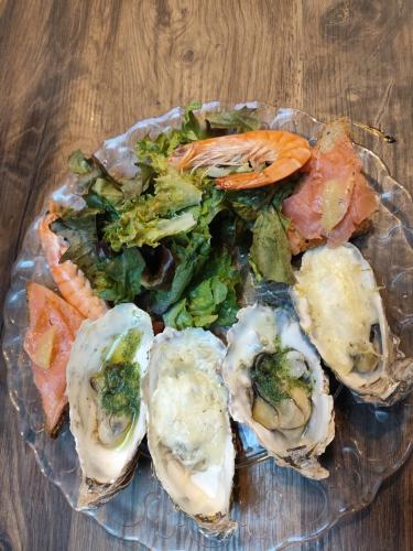 une plaque d’huîtres et de légumes sur une table en bois dans l'établissement Domaine de Corbelande, à Miniac-sous-Bécherel