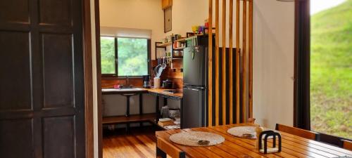 a kitchen with a wooden table and a refrigerator at Ceibo Lodge in Bijagual