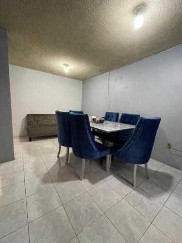 a dining room with a table and blue chairs at Amplia casa para huéspedes in Oaxaca City