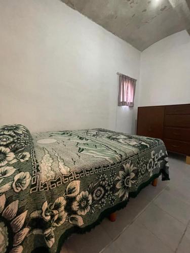a bed in a room with a blanket on it at Amplia casa para huéspedes in Oaxaca City
