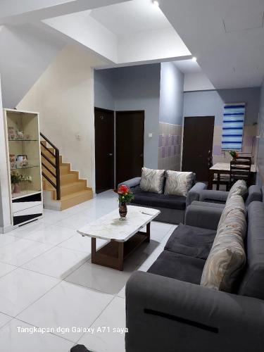 a living room with couches and a coffee table at Zahara Homestay in Sandakan