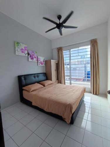 a bedroom with a bed and a ceiling fan at Zahara Homestay in Sandakan