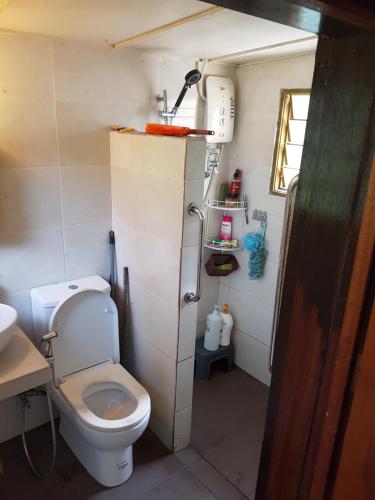 a small bathroom with a toilet and a sink at Roomstay "Ghumah Uwan" bilik kayu in Batu Kikir