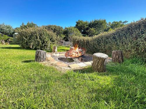 a fire pit in the middle of a field at Boutara Holiday House in Falmouth
