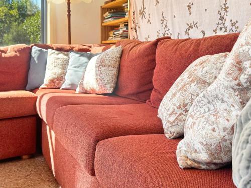 a red couch with pillows on it in a living room at Boutara Holiday House in Falmouth