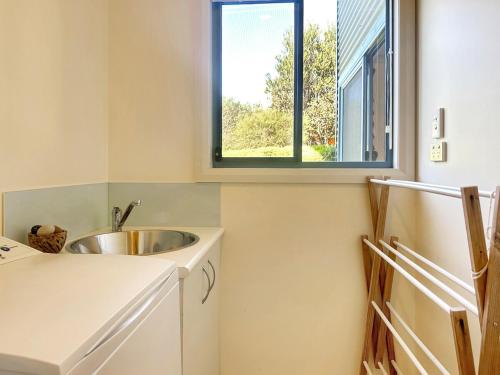 a kitchen with a sink and a window at Boutara Holiday House in Falmouth