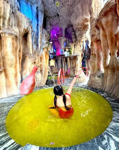 a woman swimming in a pool in a water cave at 哲帆民宿花园洋房江与城店 in Chongqing