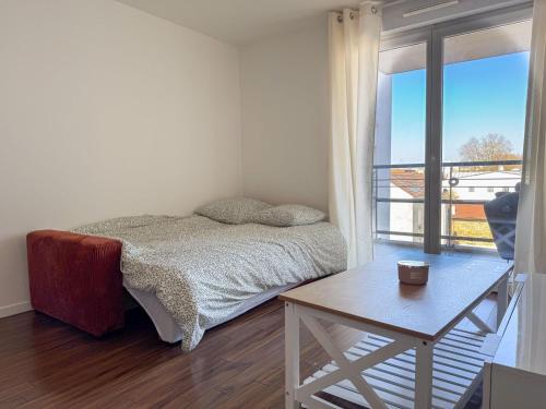 Un dormitorio con una cama y una mesa y una ventana. en House Novo Appt 10min de Paris Centre, en Aulnay-sous-Bois