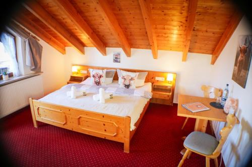 a bedroom with a large bed and a desk at House of Happiness by apartmentglück in Schluchsee