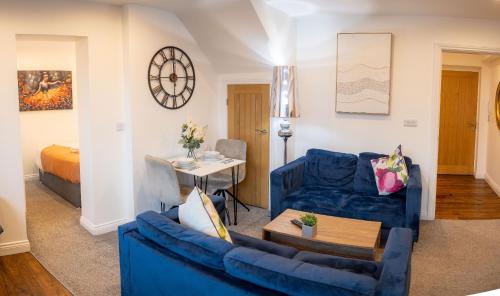 a living room with blue furniture and a bed at Hayy ApartHotels Dealhouse in Huddersfield