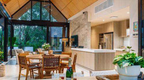 an open kitchen and dining room with a table and chairs at Niramaya Villas and Spa in Port Douglas