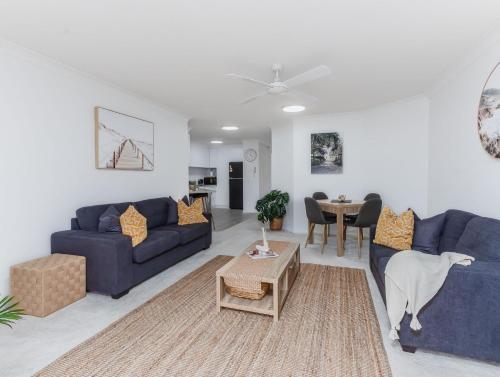 a living room with two blue couches and a table at Cabarita Beachfront - Apartment 31 in Cabarita Beach