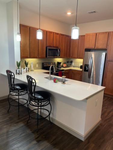 a kitchen with a white counter top and a refrigerator at Houston Luxury 1BR-3BD-Pool-Gym in Houston