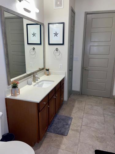a bathroom with a sink and a mirror at Houston Luxury 1BR-3BD-Pool-Gym in Houston