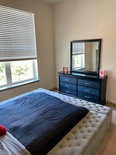 a bedroom with a bed and a dresser with a mirror at Houston Luxury 1BR-3BD-Pool-Gym in Houston