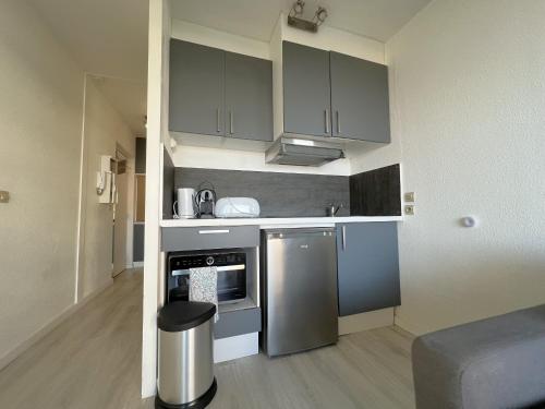 une cuisine avec des appareils en acier inoxydable dans un appartement dans l'établissement Studio cabine 4 pers bord de plage avec parking à Arcachon - FR-1-474-276, à Arcachon