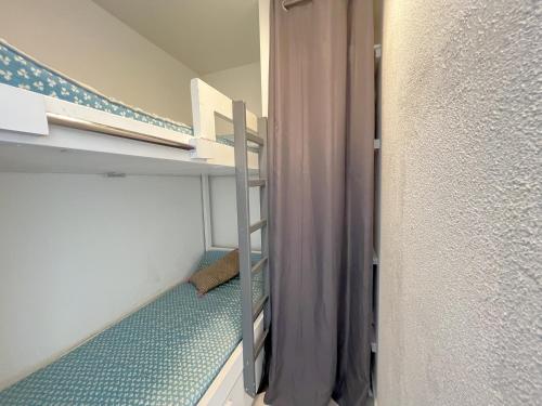 Cette petite chambre comprend des lits superposés et un escalier. dans l'établissement Studio cabine 4 pers bord de plage avec parking à Arcachon - FR-1-474-276, à Arcachon