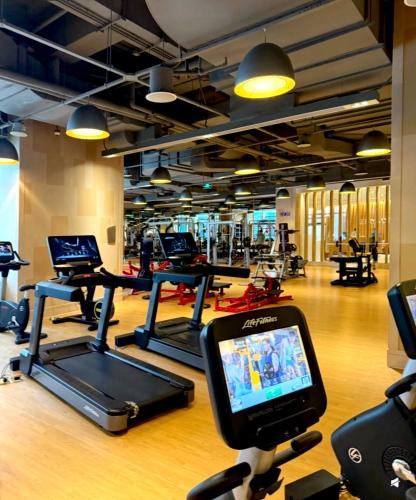 a gym with several treadmills and a treadmill at 哲帆民宿花园洋房江与城店 in Chongqing