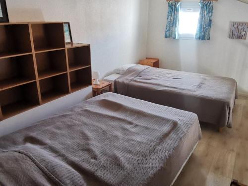 - une chambre avec 2 lits et une étagère dans l'établissement Dernière minute ! Pavillon T2 avec mezzanine, piscine et accès plage, La Tranche sur Mer - FR-1-357-60, à La Tranche-sur-Mer